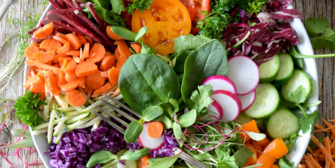 a colorful bowl full of vegetables including radishes tomatoes cucumbers