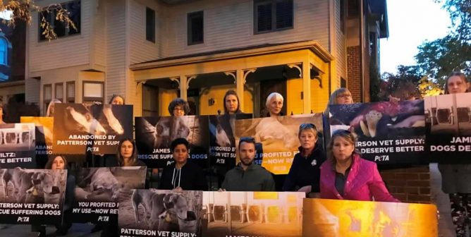 Protesters holding signs outside Patterson Vet Supply president's house