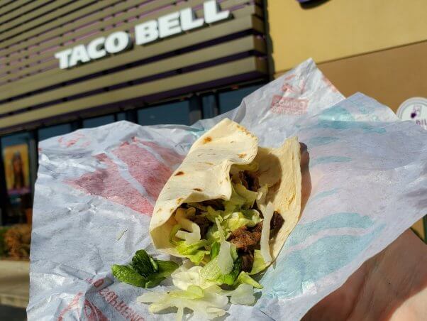 photo of vegan Beyond carne asada in a taco in front of taco bell