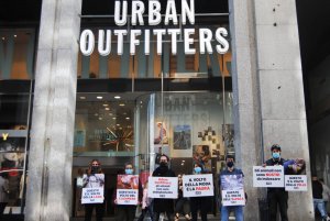 Protestors in Milan standing outside an Urban Outfitters store with posters depicting animals in pain