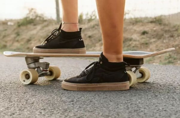 Person's legs on a skateboard wearing Loci shoes