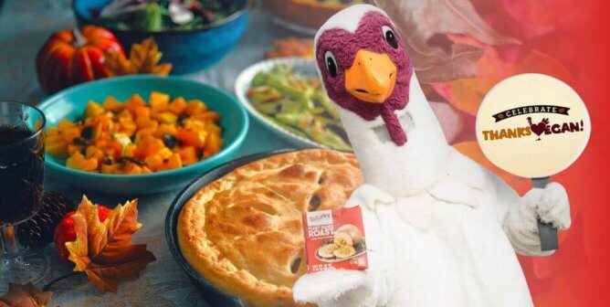 vegan thanksgiving food like squash, pie, and snap peas and turkey mascot holding "celebrate thanksvegan" sign