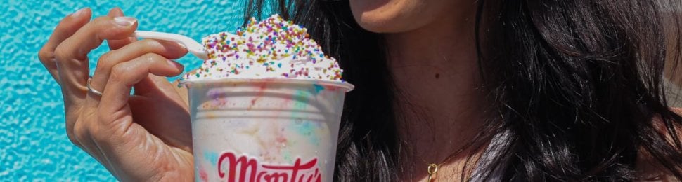 A person eating a Monty's shake with a spoon