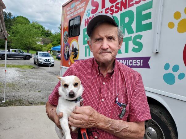 man holding his companion dog at peta's spay/neuter clinic in galax