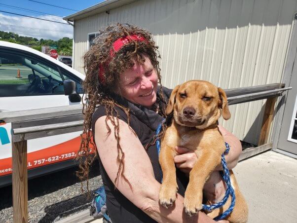 woman holds companion dog at peta's galax spay/neuter clinic