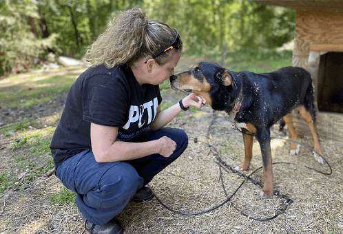 cap worker with dog outside