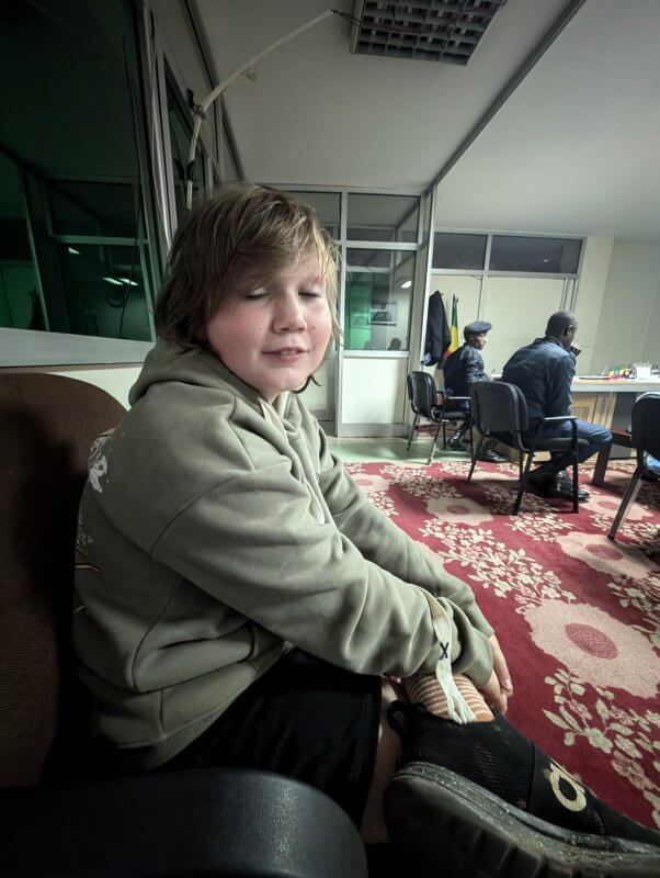child sitting on sofa in what appears to be a police holding office