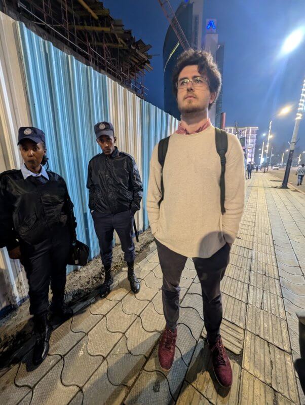 photo of Reuben Skeats standing on sidewalk with two officials behind him