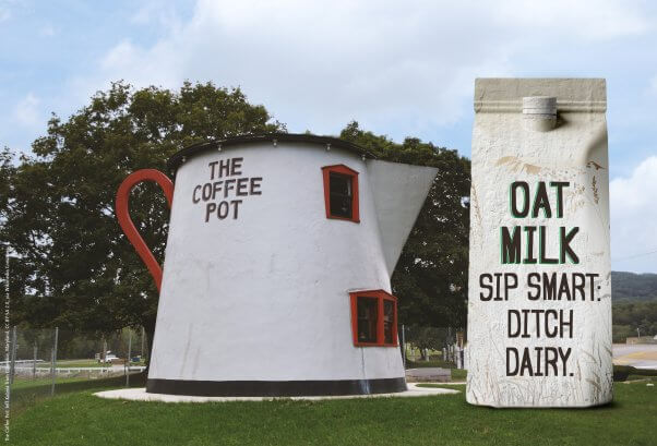 Photo of The Coffee Pot building with a mock up of a statue of a carton of oat milk with the phrase "Sip Smart: Ditch Dairy" on it