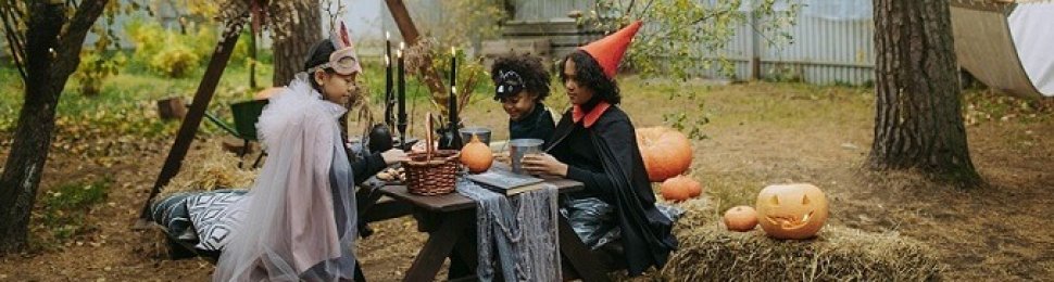 Kids making Halloween ornaments outside their house at a picnic table.