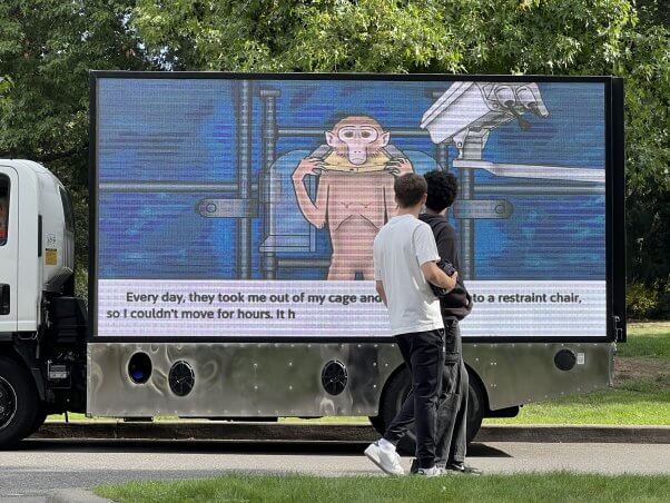 Two students walk past a mobile billboard display