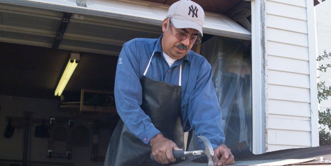 Victor Castillo hammering a nail into a wood structure