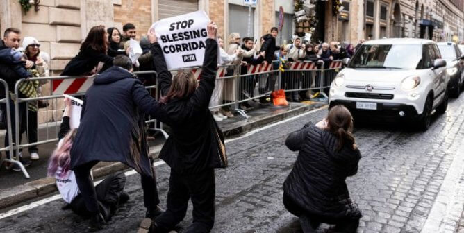 Supporters in front of the Pope's procession holding up signs