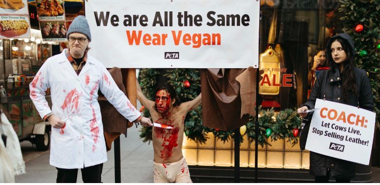 Demonstrators in costumes protesting in front of a Coach store