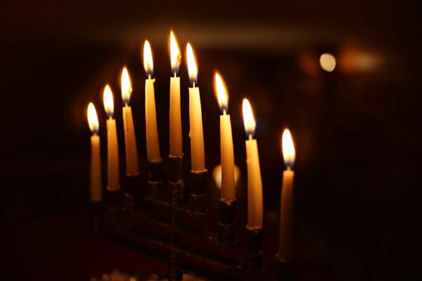 lit hanukkah menorah in a dark room