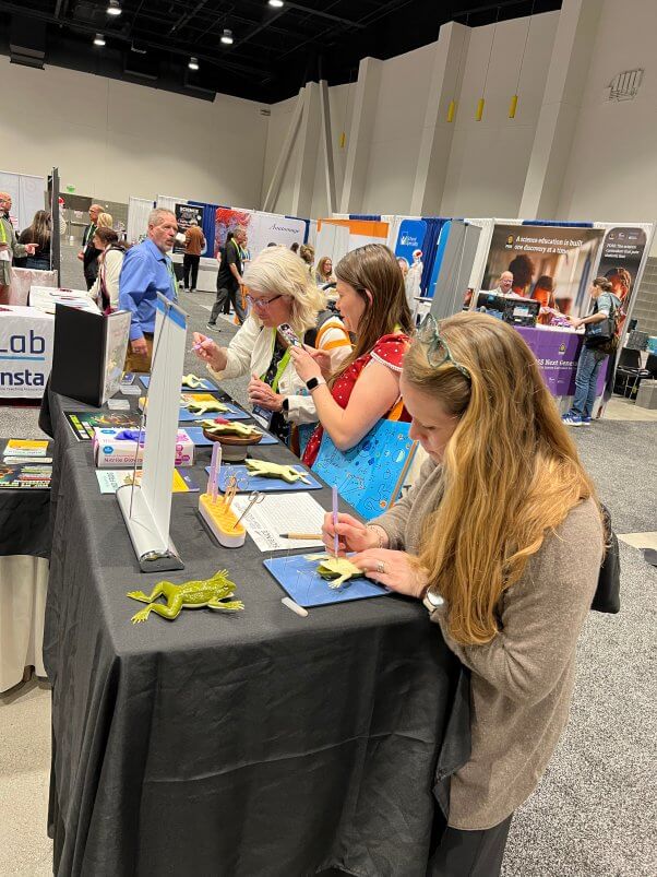 People looking at TeachKind's leaflet table