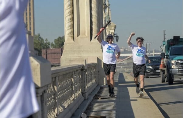 two runners along a highway overpass carrying bolt-cutters in PETA's "Run for Corky's Freedom"