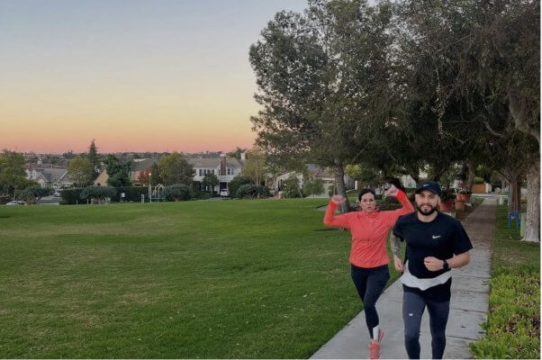 runners go up a hill on a sidewalk