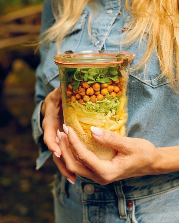 Pamela Anderson holding a mason jar filled with salad