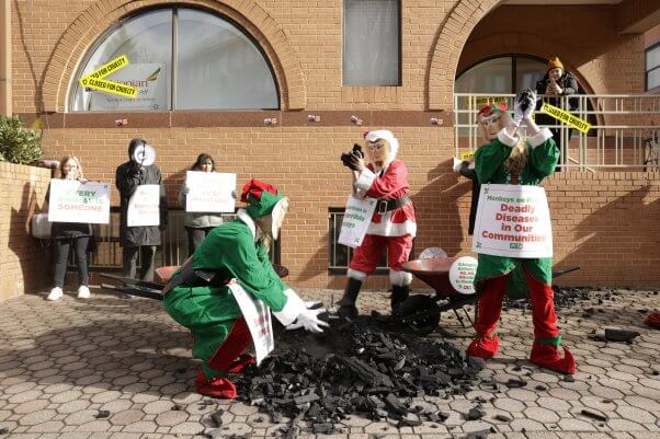 Demonstrators in monkey masks and elf costumes dumping coal