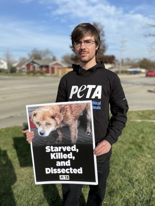 Nathan holding up a sign at a demo