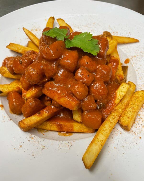 Poutine dish covered in sauce with chickpeas