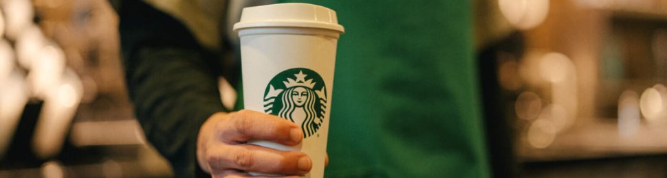 starbucks worker holding cup for warm beverages