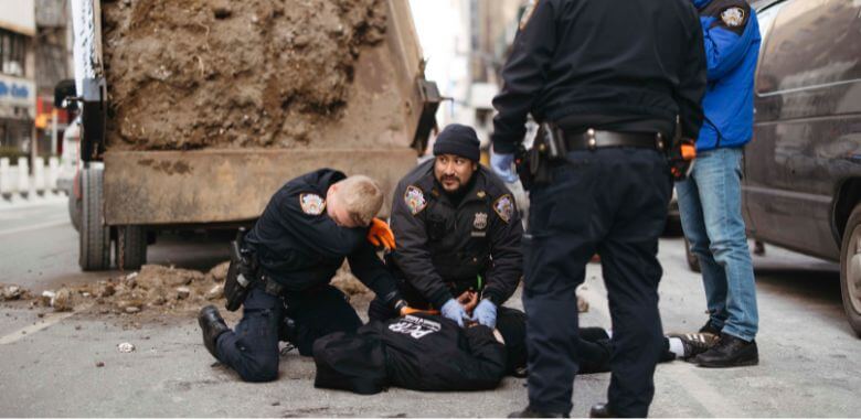 Two police officers holding down a demonstrator