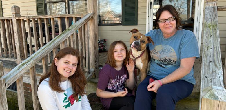 A family poses on a porch