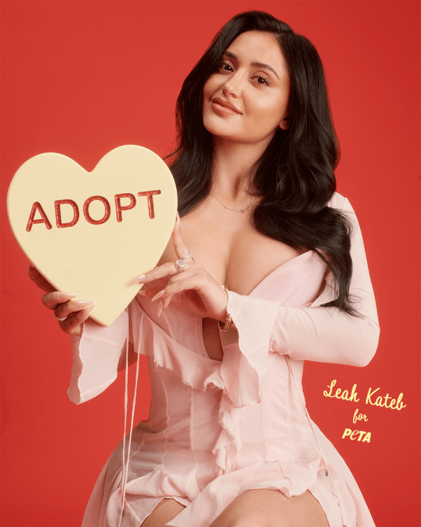 leah kateb holds a heart shaped candy that says "adopt"